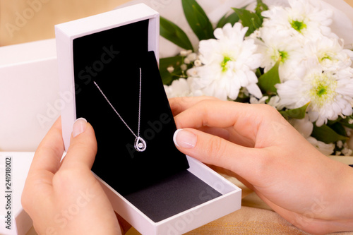hand with jewelry gift box and white flowers