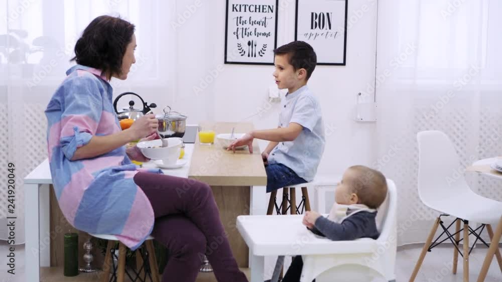 Mother and son discussing and having breakfast Mother and son discussing and having breakfast