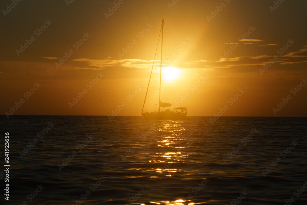 Fototapeta premium sailboat sailing on the horizon during sunset