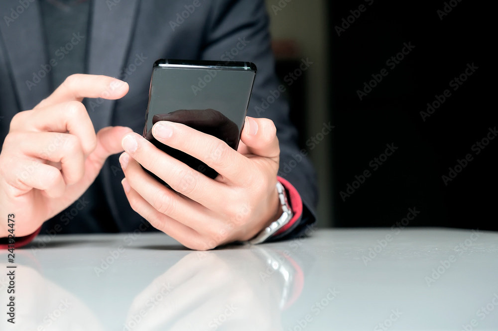 Close up of a business man using mobile smart phone while sitting at office Close up of a business man using mobile smart phone while sitting at office