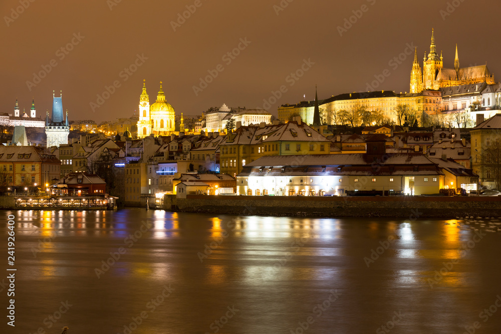 Obraz premium Night snowy Christmas Prague Lesser Town with gothic Castle above River Vltava, Czech republic