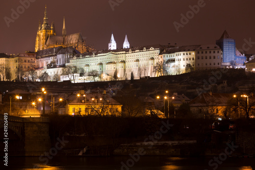 Night snowy Christmas Prague Lesser Town with gothic Castle above River Vltava, Czech republic