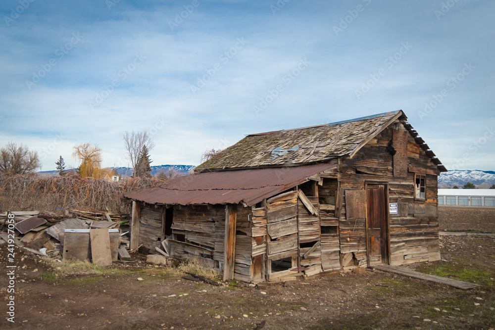Wooden shack/barn in abandoned disrepair, featuring faded 