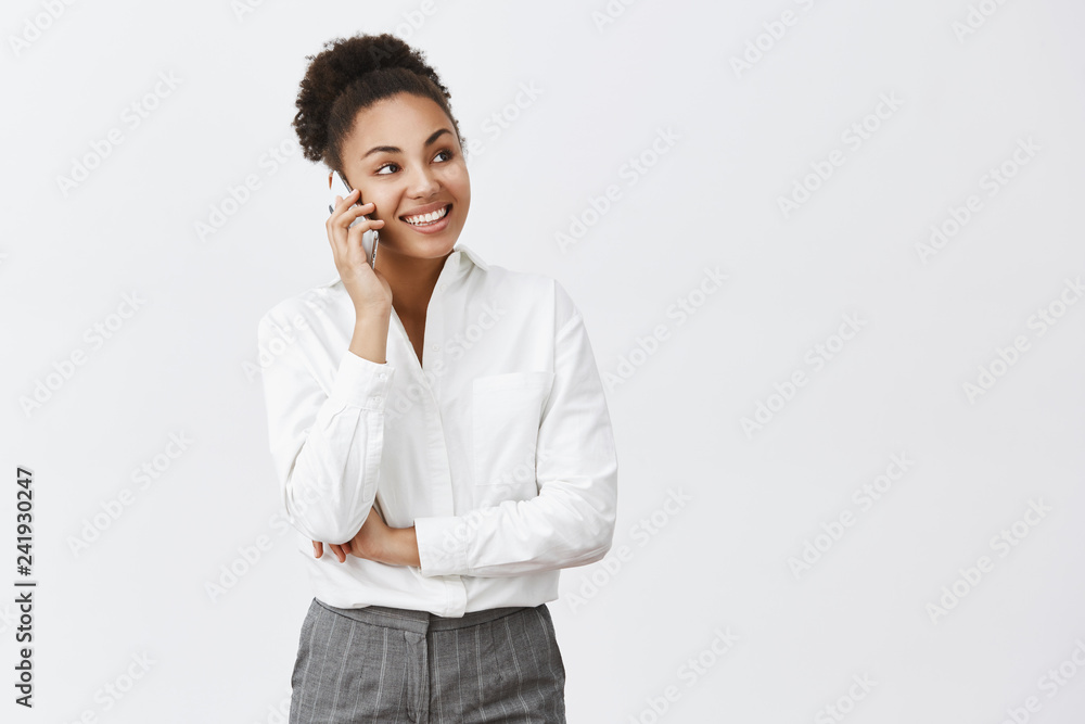 Hungry coworker calling food delivery to come quickly. Charming happy and confident creative female boss in shirt and pants, talking via smartphone, gazing aside, having interesting conversation Hungry coworker calling food delivery to come quickly. Charming happy and confident creative female boss in shirt and pants, talking via smartphone, gazing aside, having interesting conversation