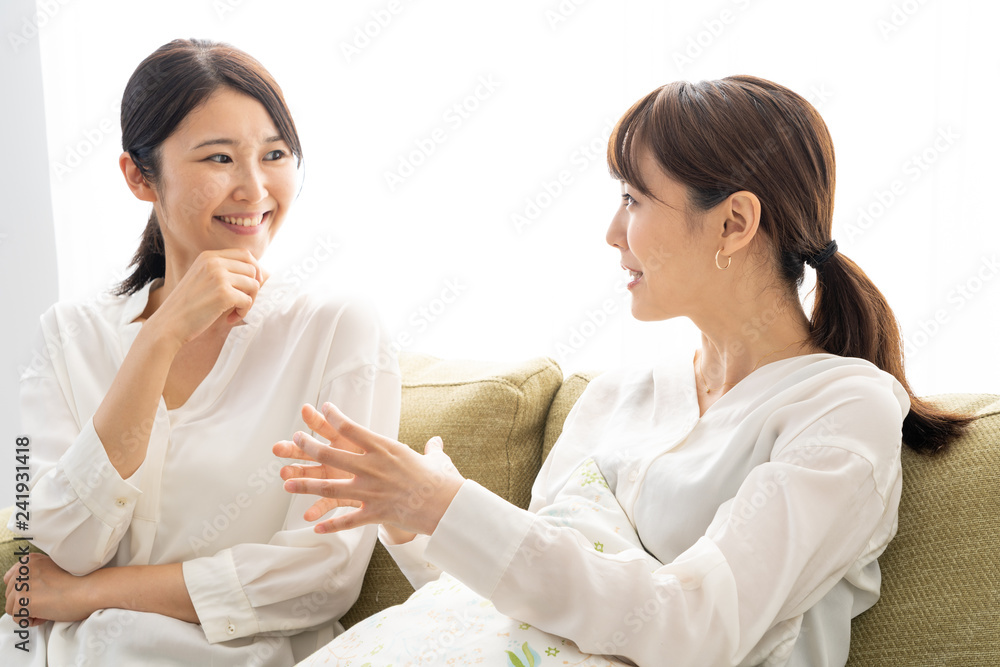 two young asian women relaxing in living room