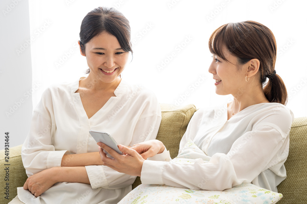 two young asian women relaxing in living room two young asian women relaxing in living room