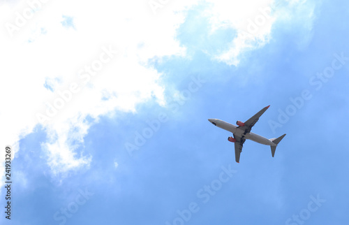 Image of a plane is flying in cloudy blue sky. The way of transportation in modern world. The symbol of going directly to the goal of business. 