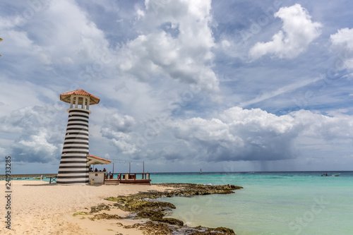 Bayahibe, Dominican Republic - July 22nd 2018 - Tourists enjoying the Bayahibe beach in front of the lighthouse in Dominican Republic
