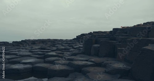 hand hold shoot view of walking on the giant causeway hexagon stone and move forward 