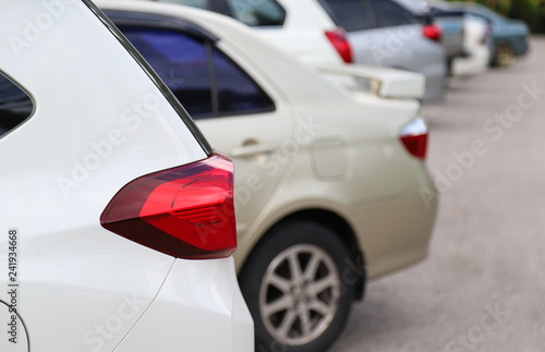 Closeup of rear side of white cars park in parking area in sunny day.  © Amphon