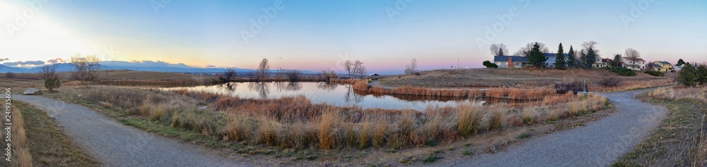 Views of Josh’s Pond walking path, Reflecting Sunset in Broomfield Colorado surrounded by Cattails, plains and Rocky mountain landscape during sunset. United States. Views of Josh’s Pond walking path, Reflecting Sunset in Broomfield Colorado surrounded by Cattails, plains and Rocky mountain landscape during sunset. United States.