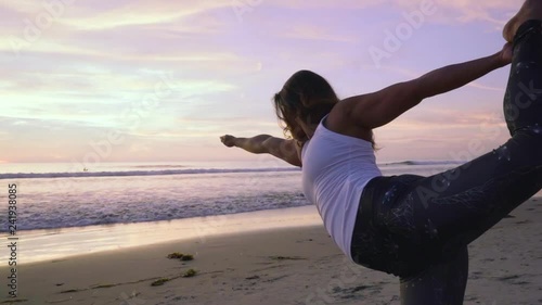 Yoga standing bow posture during colour sunset california