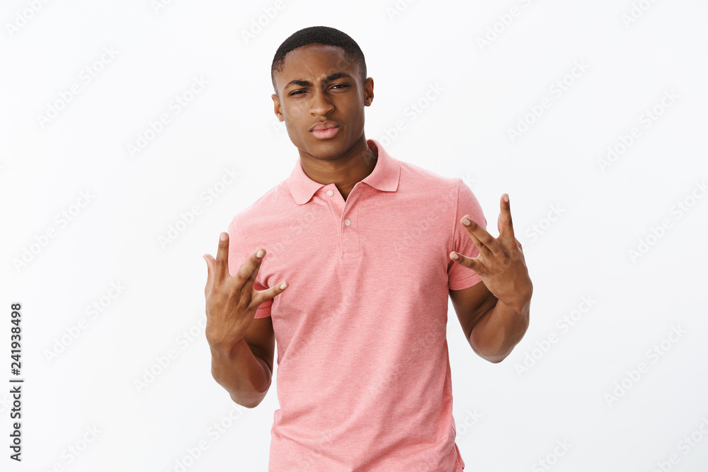 Guy got swag. Portrait of confident good-looking self-satisfied young  african american guy acting cool and cockish crossing fingers being street  dude frowning to make serious face over gray background Stock-Foto | Adobe