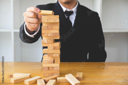 Businessmen picking dominoe blocks to fill the missing dominoes. Growing business concept.