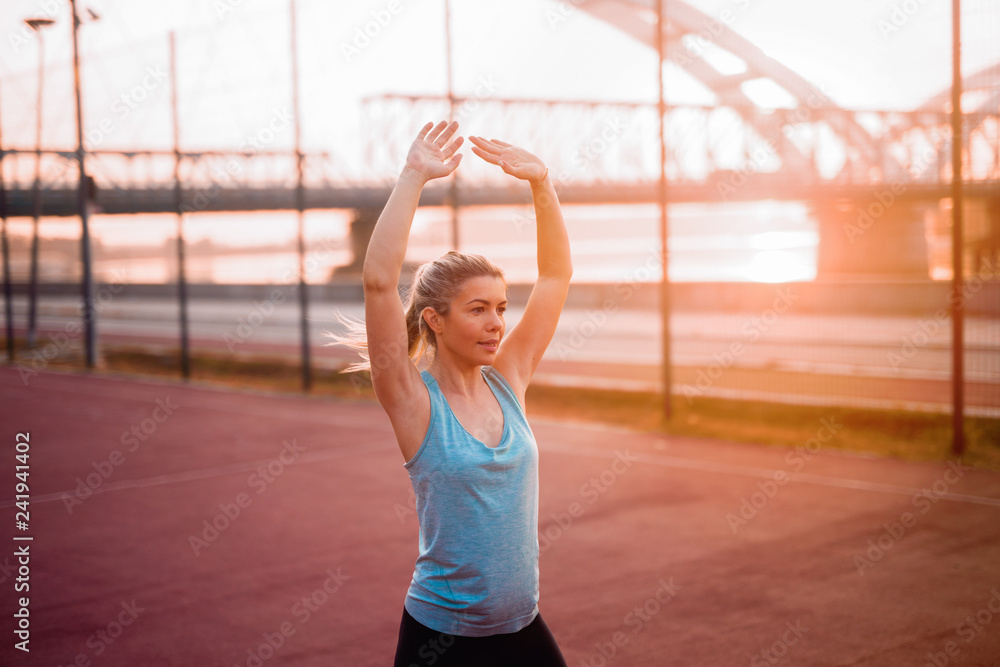 Strong cute young girl working out on training field. Strong cute young girl working out on training field.