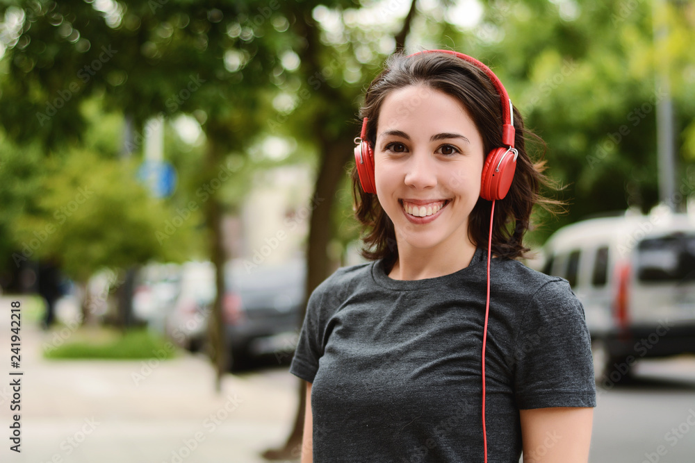 Portrait of young beautiful woman with red headphones listening music Portrait of young beautiful woman with red headphones listening music