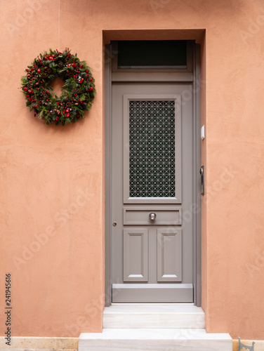 Christmas wreath decoration. Wooden entrance door in old town of Plaka, Athens Greece.