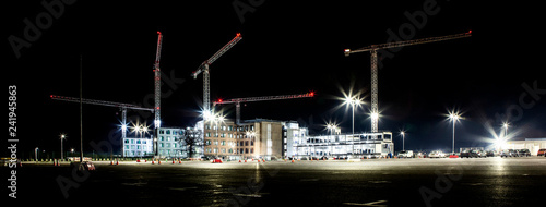 Building site with cranes by night