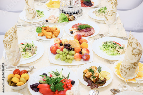 Served for a banquet table. Wine glasses with napkins, glasses, fruits and salads