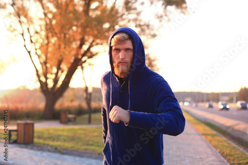 Fototapeta Naklejka Na Ścianę i Meble -  Fit athlete. Handsome adult man running outdoors to stay healthy, at sunset or sunrise. Runner.
