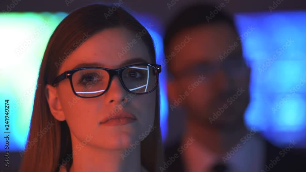 The businesswoman and a businessman smiling in the dark office The businesswoman and a businessman smiling in the dark office