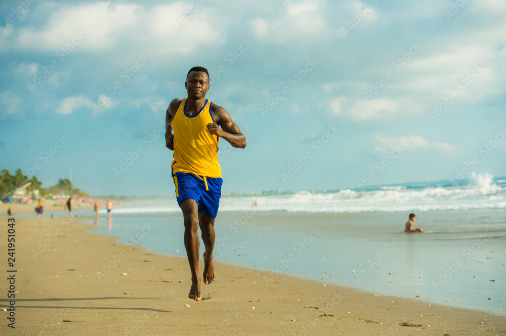 young attractive fit athletic and strong black afro American man running at the beach training hard and sprinting on sea water in professional athlete lifestyle young attractive fit athletic and strong black afro American man running at the beach training hard and sprinting on sea water in professional athlete lifestyle