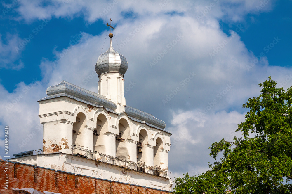 Ancient orthodox bell tower against the blue sky.