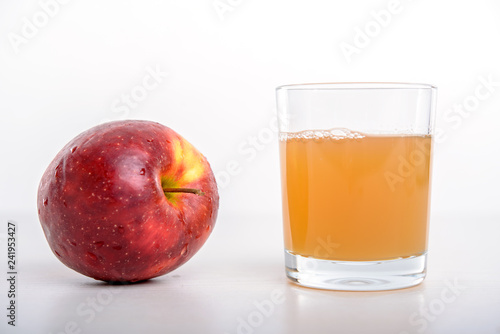 red apple with glass of naturally cloudy juice