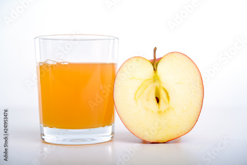 half apple with glass of naturally cloudy juice