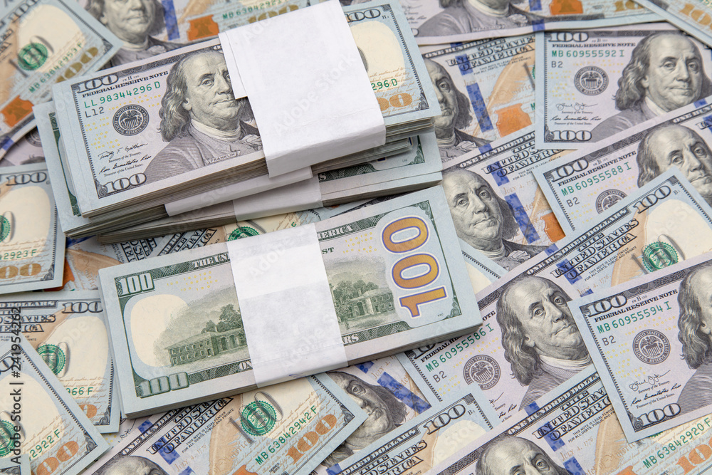 One hundred dollar bills on the table as background One hundred dollar bills on the table as background