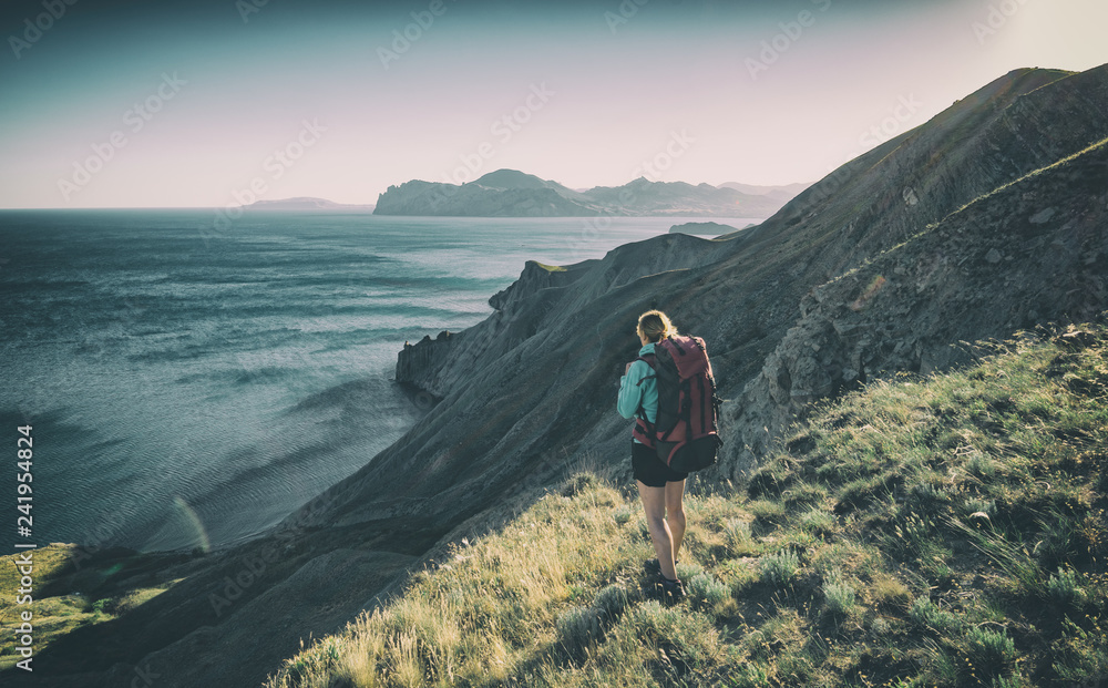 Fototapeta premium Girl hiker on a the edge above the sea