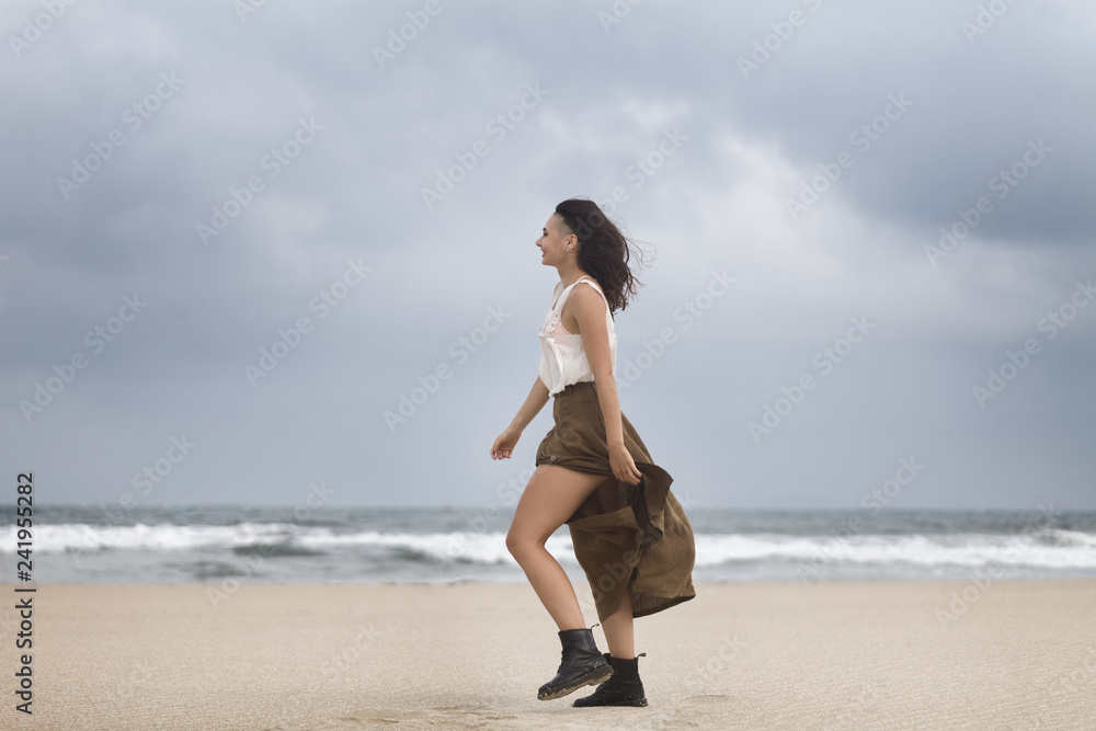 Lifestyle portrait of happy carefree woman walking on the beach