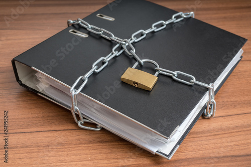 Cuadro en lienzo Confidential files and documents in binder locked with padlock and chain