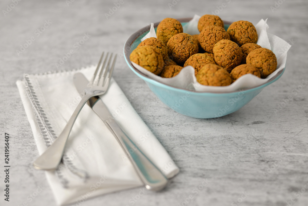 Baked chickpea falafel balls on blue plate on grey background , healthy and vegan food with tahini deep and hot pepper , traditional Mediterranean , top view , flat lay with copy space Baked chickpea falafel balls on blue plate on grey background , healthy and vegan food with tahini deep and hot pepper , traditional Mediterranean , top view , flat lay with copy space