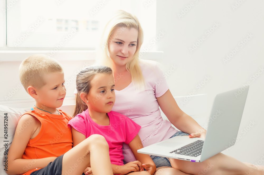 Happy mother and kids using digital laptop at home Happy mother and kids using digital laptop at home