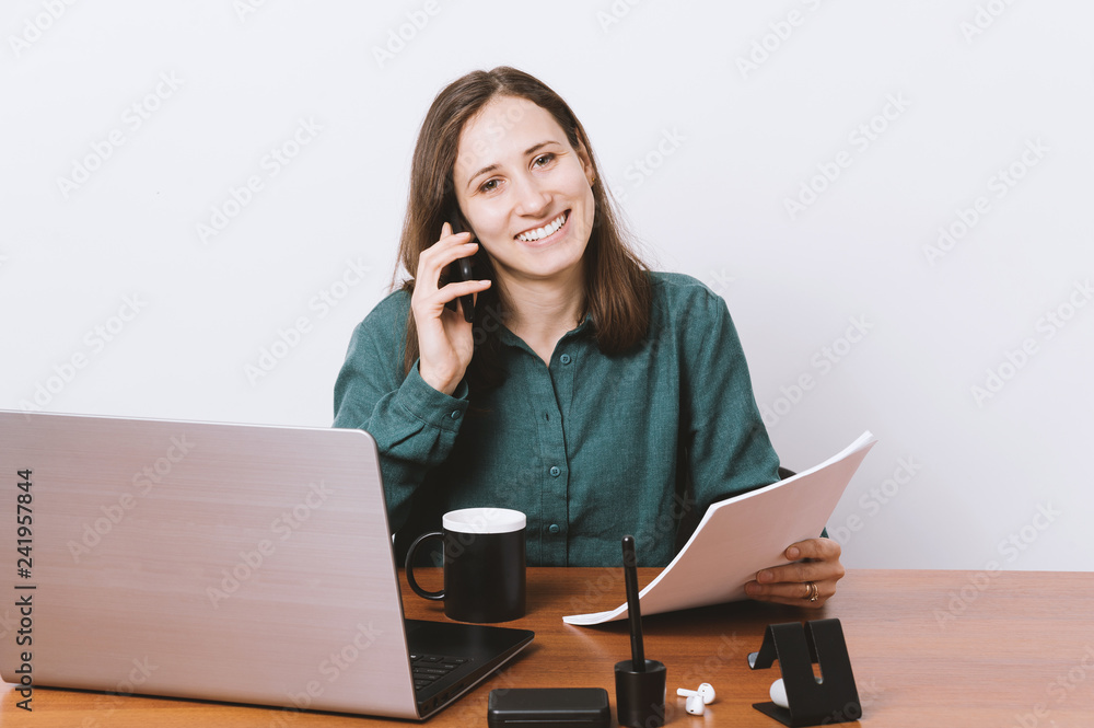 Smiling Business woman talking on phone and do her paper work Smiling Business woman talking on phone and do her paper work