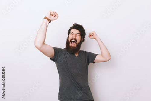 Portrait of screaming, excited bearded man, celebrating his winn photo