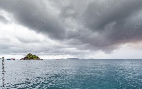beautiful scenic island with traveling boat while raining strom near comes