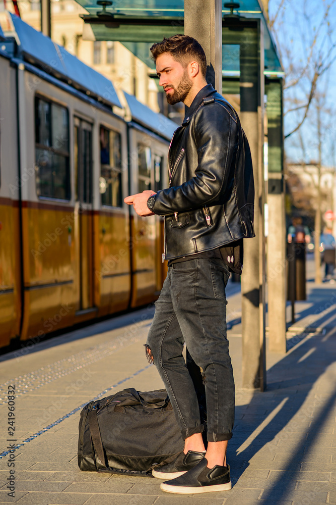 Young man waiting in a tram station Young man waiting in a tram station