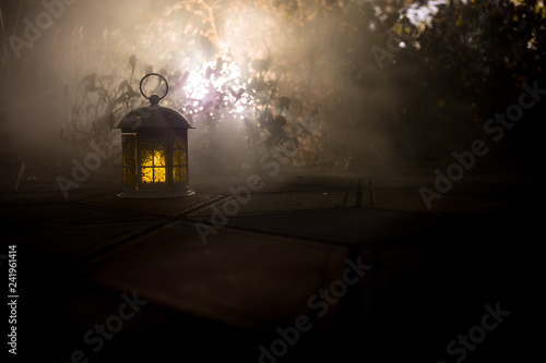 Retro style lantern at night. Beautiful colorful illuminated lamp at the balcony in the garden. Selective focus