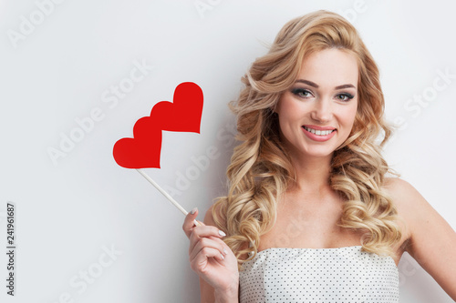 Positive girl holds red hearts