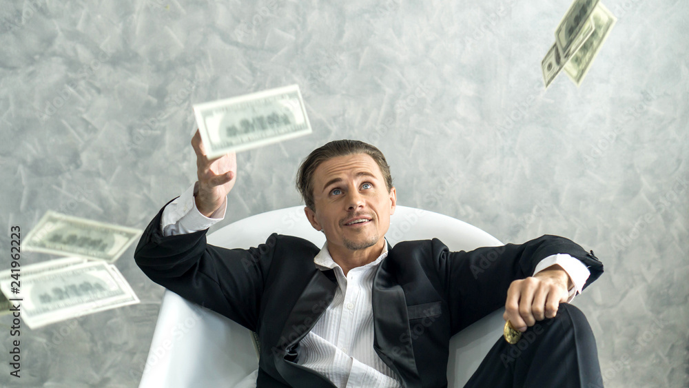 Happy business man very rich guy throw money dollar bills in air like