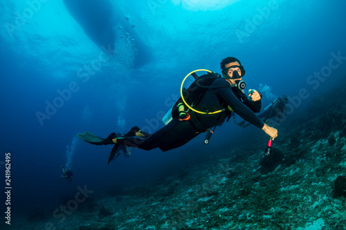 Male SCUBA diver exploring a tropical coral reef in Thailand © whitcomberd