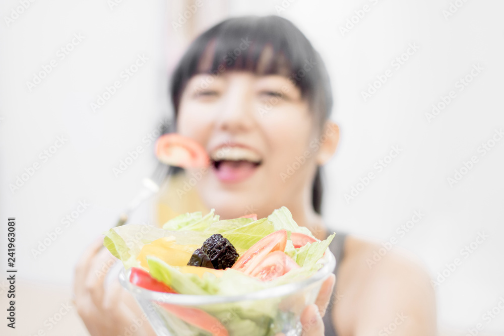 Portrait of a fit healthy asian woman who is eating a fresh salad. Portrait of a fit healthy asian woman who is eating a fresh salad.
