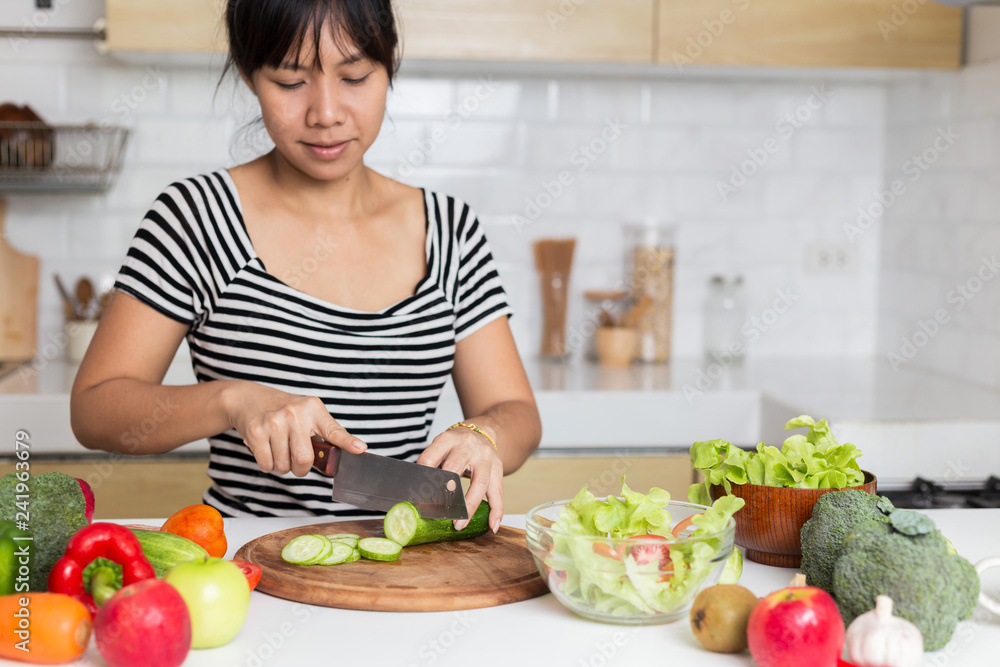 Healthy food Asian woman is cooking salad in kitchen, female preparing the vegetables and fruit at her house