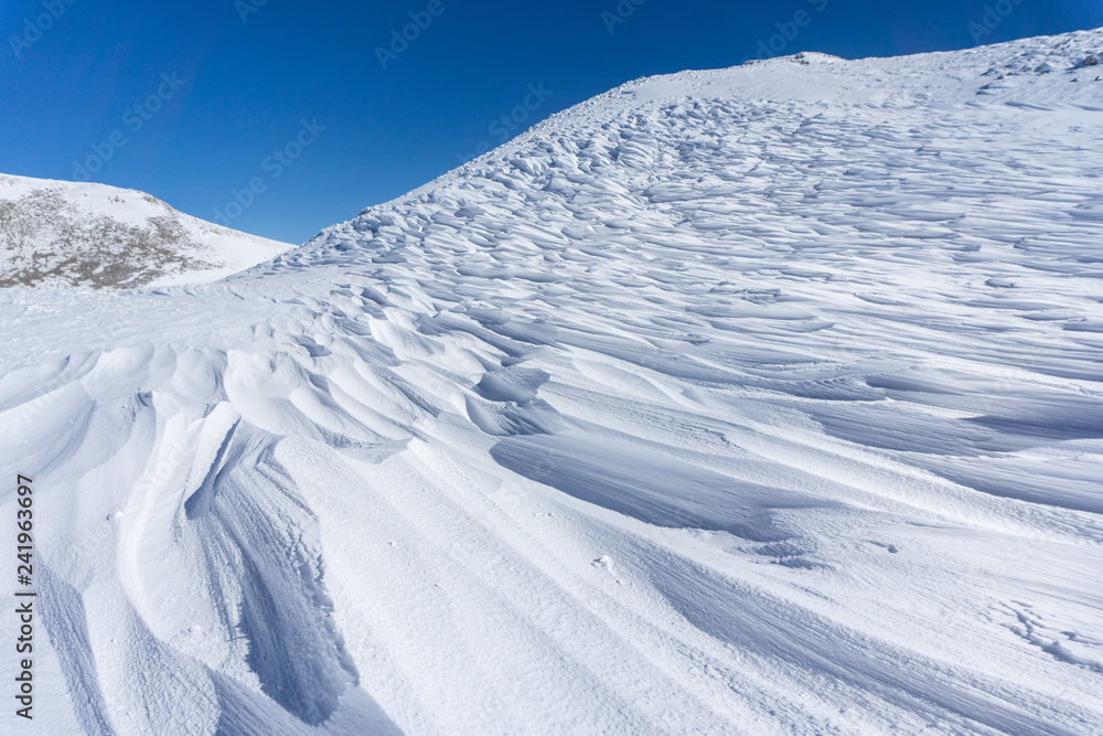 Winter landscape with wind sculpted patterns on snow- wind effect