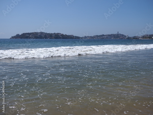 Scenery of calm beach at bay of ACAPULCO city in Mexico and white waves of Pacific Ocean landscape