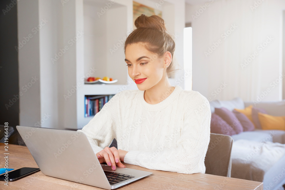 Young woman using laptop while working from home Young woman using laptop while working from home