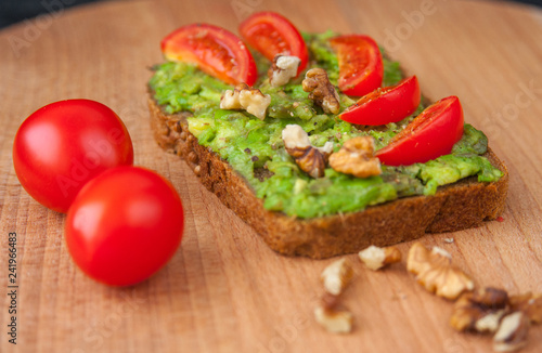 Sandwich with avocado tomatoes and nuts. Healthy diet.