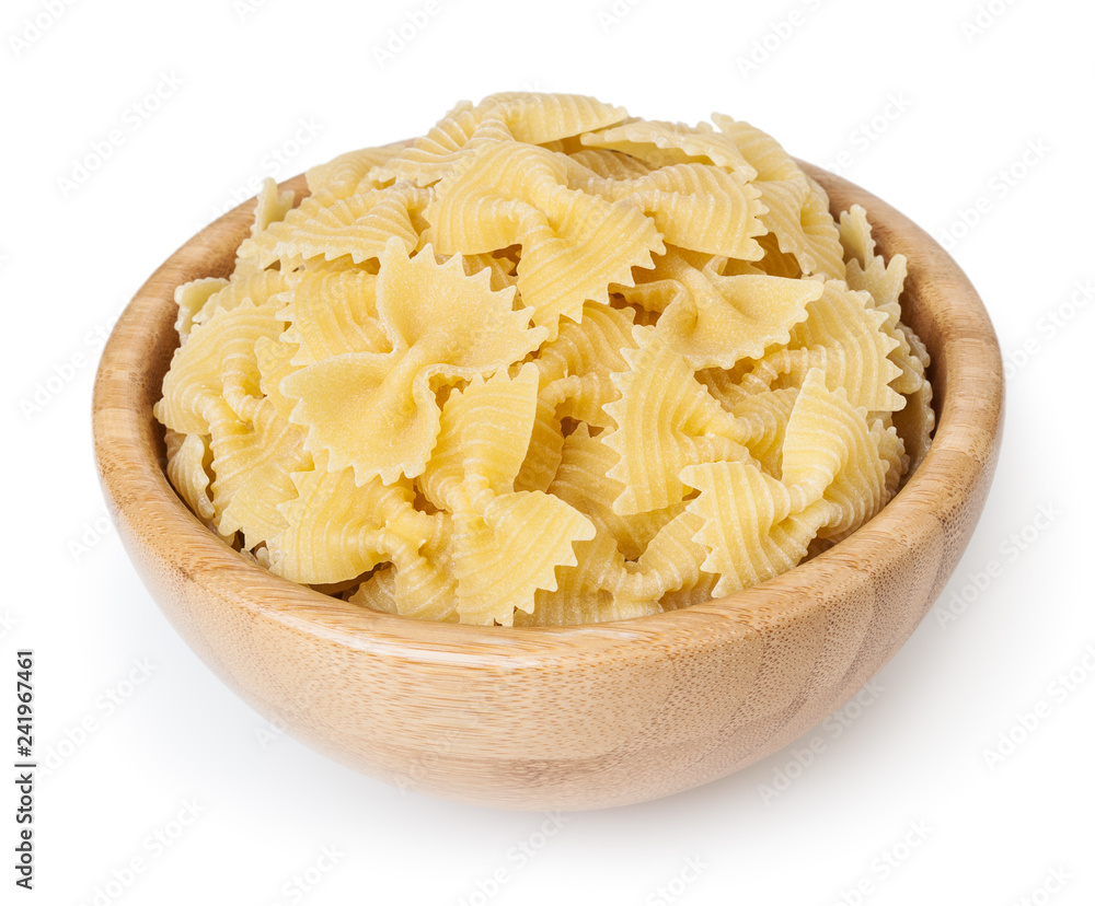 Farfalle pasta in wooden bowl isolated on white background with clipping path - obrazy, fototapety, plakaty 